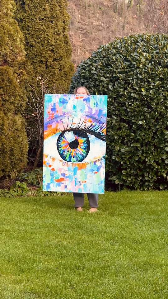 Evelyne hält Das Auge im Garten vor sich